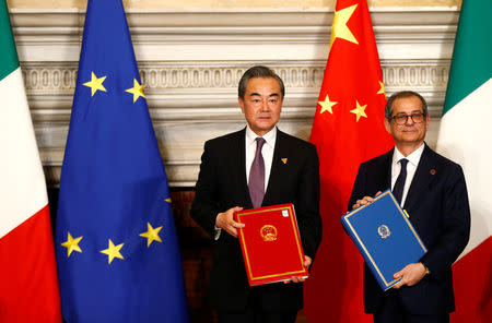 Chinese Foreign Minister Wang Yi and Italian Economy Minister Tria pose after signing trade agreements at Villa Madama in Rome, Italy March 23, 2019. REUTERS/Yara Nardi