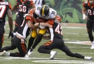 Oct 14, 2018; Cincinnati, OH, USA; Pittsburgh Steelers running back James Conner (30) is tackled by Cincinnati Bengals safety Clayton Fejedelem (42) and linebacker Jordan Evans (50) during the second half at Paul Brown Stadium. Mandatory Credit: David Kohl-USA TODAY Sports