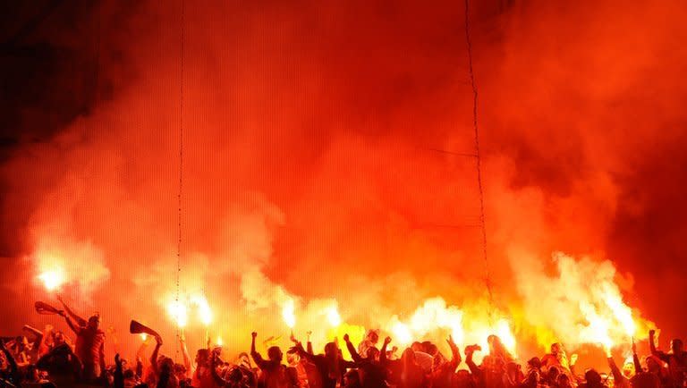 Galatasaray's supporters light flares during the UEFA Champions League quarter-final first leg football match Real Madrid vs Galatasaray on April 3, 2013 at Santiago Bernabeu stadium in Madrid. Real won 3-0