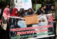 FILE PHOTO: People and family members hold signs and banner demanding evacuation of Pakistani students from Wuhan city in China, who couldn’t go back after the coronavirus outbreak, during a protest outside Chinese Consulate in Lahore