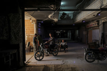 A man sits on a motorcycle at the entrance of a hospital in Douma, outside Damascus, Syria, September 17, 2018. The town of Douma in eastern Ghouta was retaken by the government from rebels in April after heavy fighting and intense army bombardment and air strikes. REUTERS/Marko Djurica