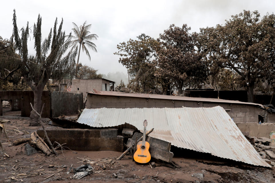 <p>A guitar is seen on top of a roof of a house affected by the eruption of the Fuego volcano at San Miguel Los Lotes in Escuintla, Guatemala, June 8, 2018. (Photo: Carlos Jasso/Reuters) </p>