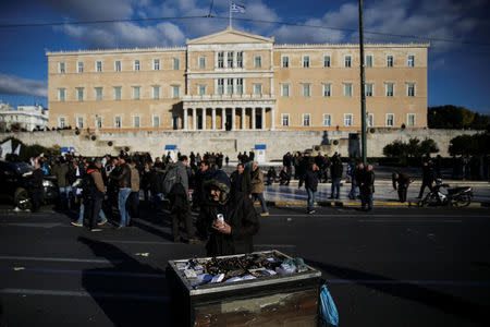 An elderly man sells chestnuts in front of the parliament during a demonstration to demand tax reductions and compensation in Athens, Greece, February 14, 2017. REUTERS/Alkis Konstantinidis