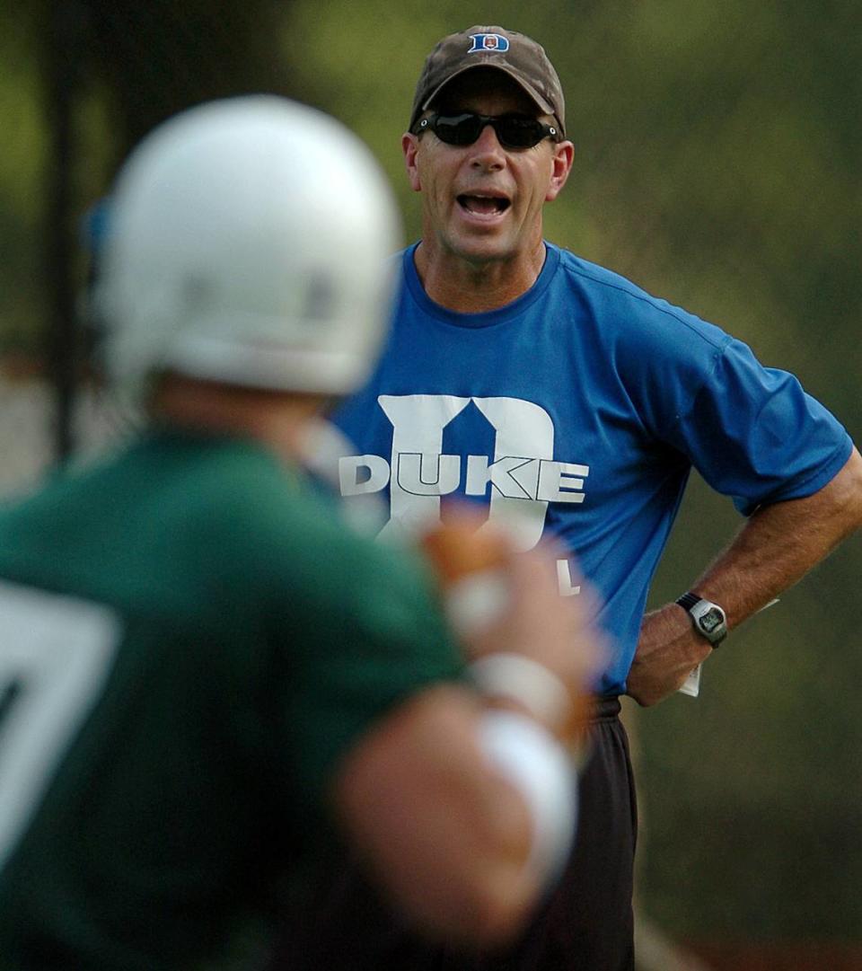 08/10/04 First year Duke Blue Devils quarterbacks coach Tom Knotts yells instructions to quarterback (7) Mike Schneider during drills Tuesday afternoon. JEFF SINER/STAFF