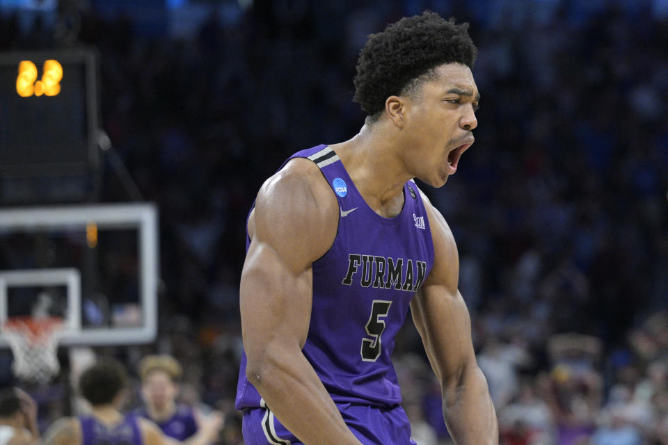 Furman guard Marcus Foster (5) celebrates after what proved to be the game-winning basket by guard JP Pegues during the second half of a first-round college basketball game against Virginia in the NCAA Tournament, Thursday, March 16, 2023, in Orlando, Fla. (AP Photo/Phelan M. Ebenhack)