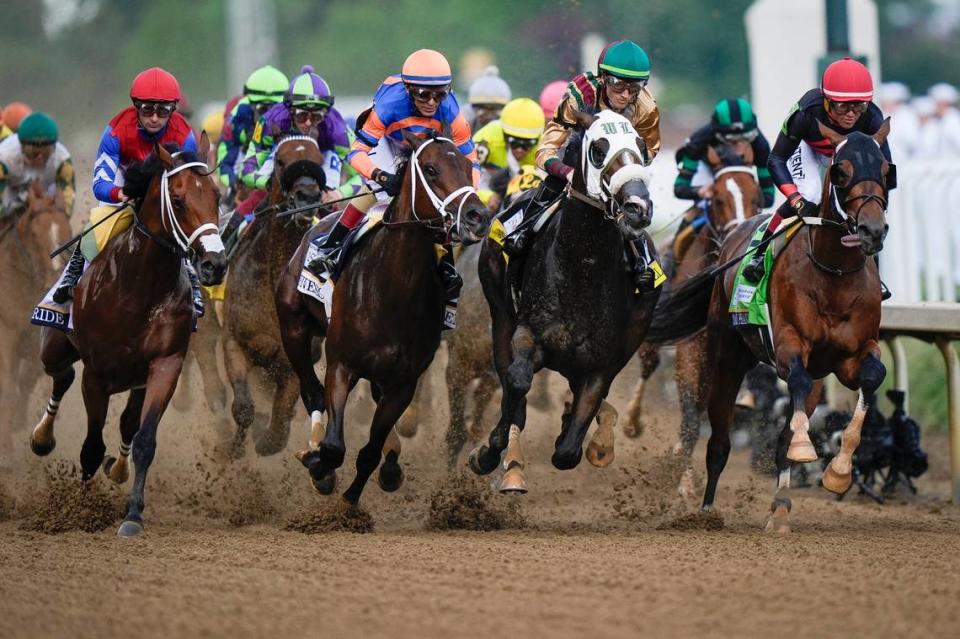 The field of horses runs down the front stretch for the first time during the 150th running of the Kentucky Derby at Churchill Downs.