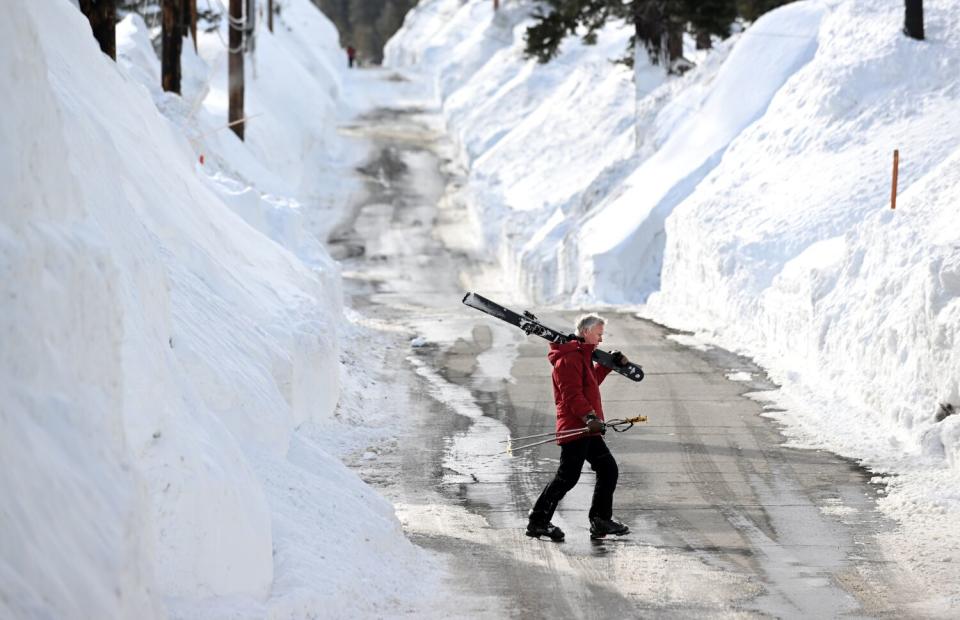 David Frazier crosses Davison Road after a day of skiing at Mammoth Mountain.