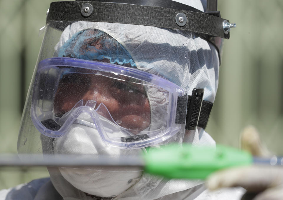 A worker in protective suit disinfects a school which has suspended classes as a precautionary measure against a new coronavirus in San Juan city, east of Manila, Philippines on Monday, March 9, 2020. Philippine President Rodrigo Duterte has declared a state of public health emergency throughout the country after health officials confirmed over the weekend the first local transmission of the new coronavirus. (AP Photo/Aaron Favila)