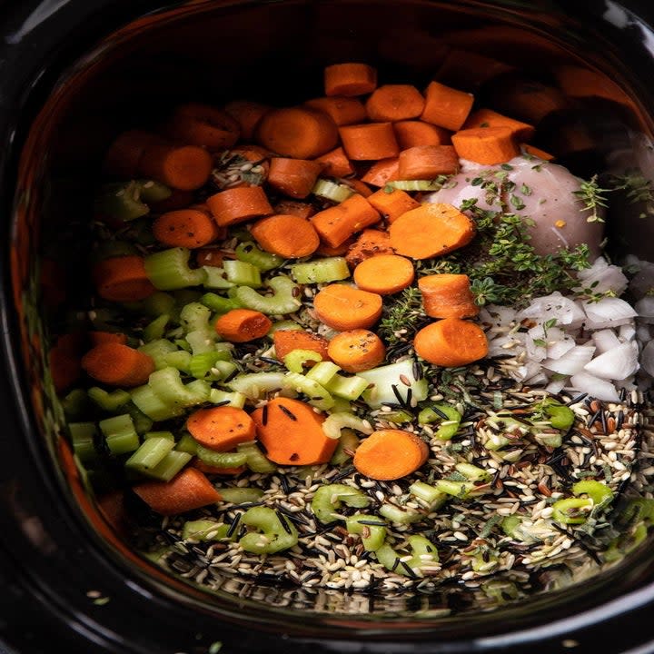 ingredients for creamy wild rice chicken soup in a slow cooker