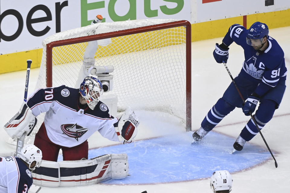 Columbus Blue Jackets goaltender Joonas Korpisalo (70) makes a save as Toronto Maple Leafs center John Tavares (91) looks for a rebound during the third period of an NHL Eastern Conference Stanley Cup playoff game in Toronto on Sunday, Aug. 9, 2020. (Nathan Denette/The Canadian Press via AP)