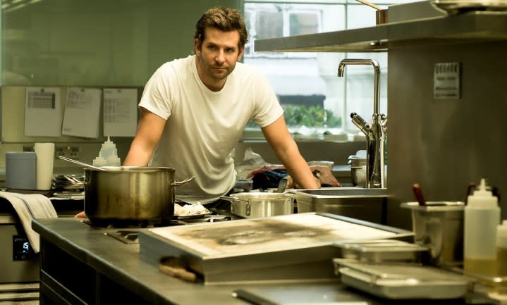 A man stands behind a table in Burnt.