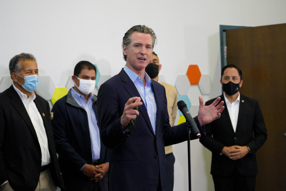 Governor Gavin Newsom speaks with news reporters about San Diego's newest pop-up vaccination site at the Park de la Cruz Recreation Center in the City Heights neighborhood on Friday, April 2, 2021. Accompanying Newsom was Juan Vargas, Ben Hueso, Sean Elo-Rivera and Todd Gloria. (Nelvin C. Cepeda/The San Diego Union-Tribune via AP)