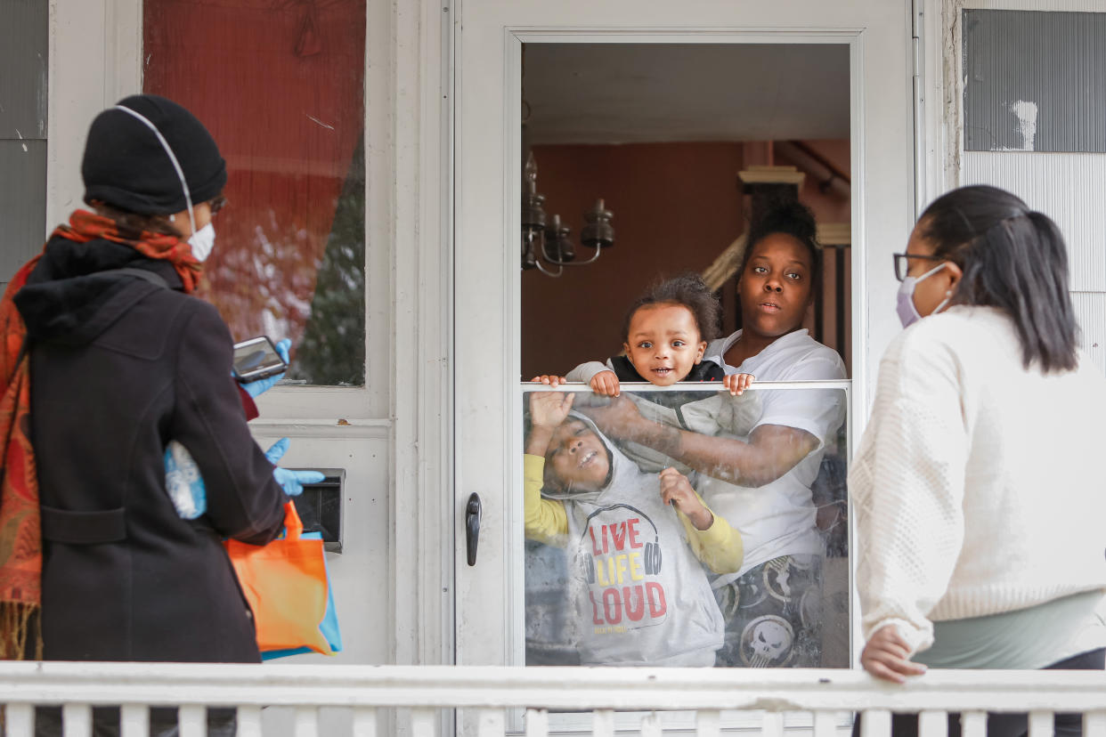 Sister Jenthia and Dr. Angela Branche hand out coronavirus disease (COVID-19) survival kit to Natalie Hall as part of a door-to-door outreach program to the Black community to increase vaccine trial participation in Rochester, New York, U.S., October 17, 2020. Picture taken October 17, 2020.  REUTERS/Lindsay DeDario