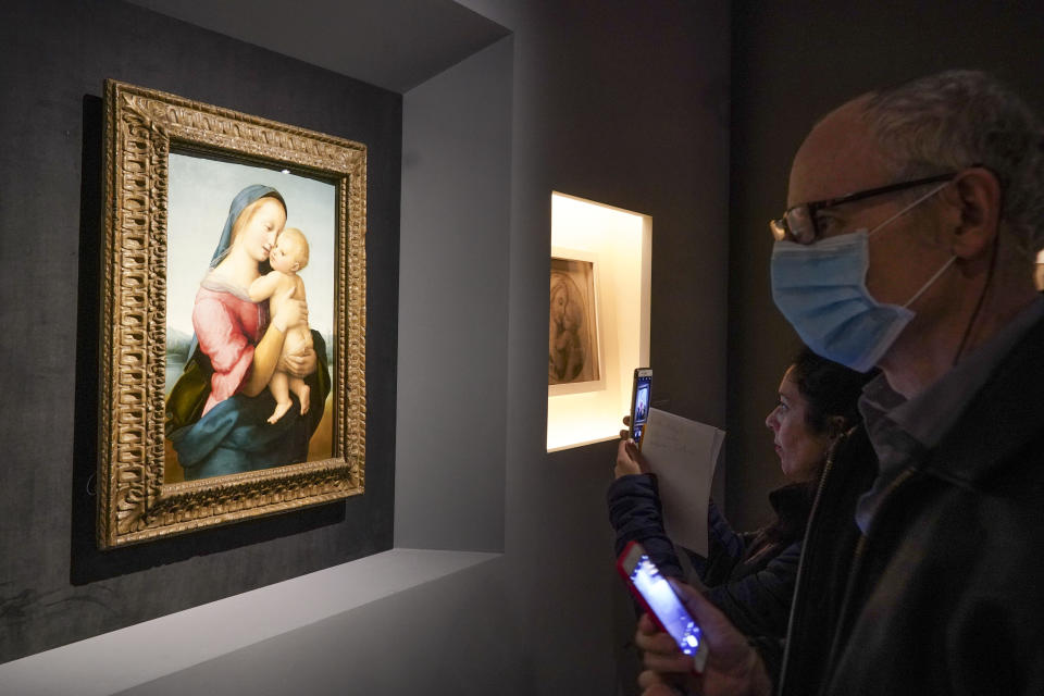 A man looks at Raphael's oil on wood panel, Madonna con il Bambino (Virgin with the Child), in Rome, Wednesday, March 4, 2020. The paintings, drawings and sketches in the most ambitious assemblage ever of Raphael works in an exhibition, more than even the Renaissance superstar had in his workshop at one time, are collectively insured for 4 billion euros ($.4 billion), against the likes of theft or vandalism. But no money can guarantee that Italy’s outbreak of coronavirus, the largest in Europe, won’t play havoc with the three-month run in Rome of the art world’s eagerly-awaited blockbuster. (AP Photo/Andrew Medichini)