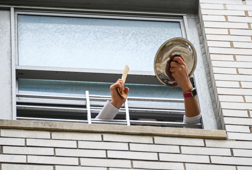 A person applauds from their window to show their gratitude to medical staff and essential workers working on the front lines of the coronavirus pandemic in New York City, May 18, 2020. (Photo by Noam Galai/Getty Images)
