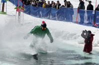 A skier participates in a pond skimming event at Gunstock Mountain Resort, Sunday, April 7, 2024, in Gilford, N.H. The wacky spring tradition is happening this month at ski resorts across the country and is often held to celebrate the last day of the skiing season. (AP Photo/Nick Perry)