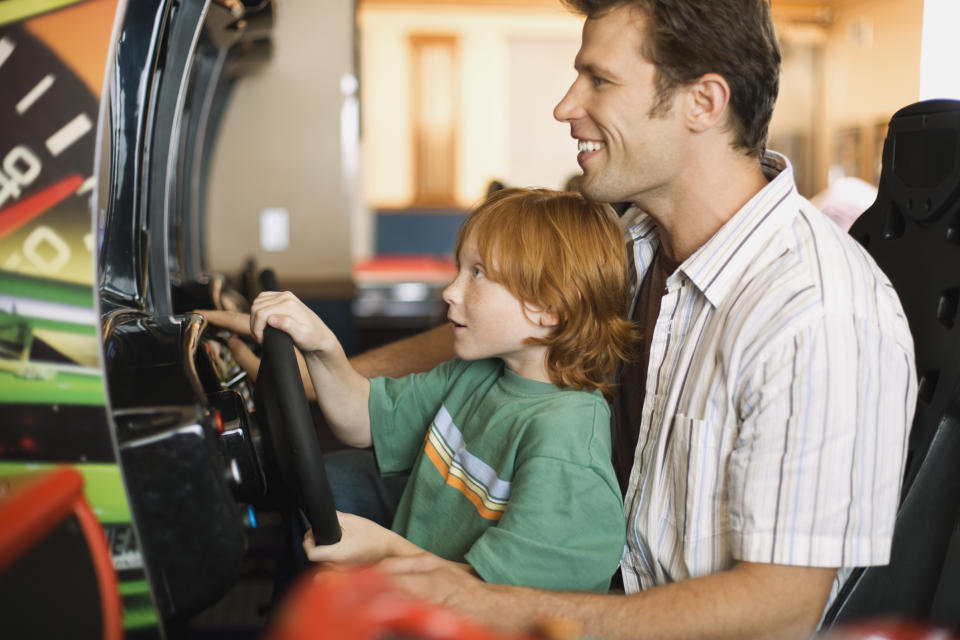 A father and son playing arcade games.