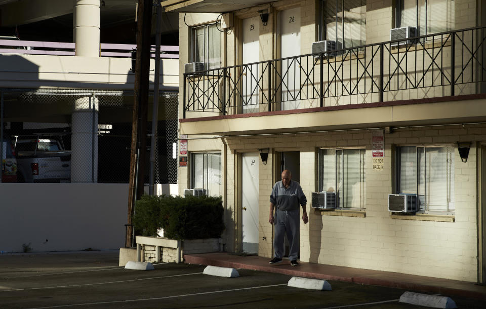 In this Oct. 12, 2018, photo, a man walks out of a weekly rental motel in Reno, Nev. The economic recovery has allowed Reno to reclaim its status as a boomtown, but that has been bad news for people on the margins who are having a harder time finding an affordable place to live, forcing many into the dozens of weekly rental motor lodges around the city. (AP Photo/John Locher)