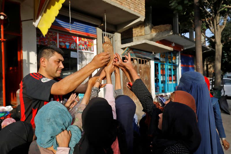 People reach out to receive bread in Kabul