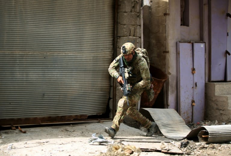 An Iraqi soldier runs for cover as government forces battle Islamic State group jihadists for control of Mosul's Old City