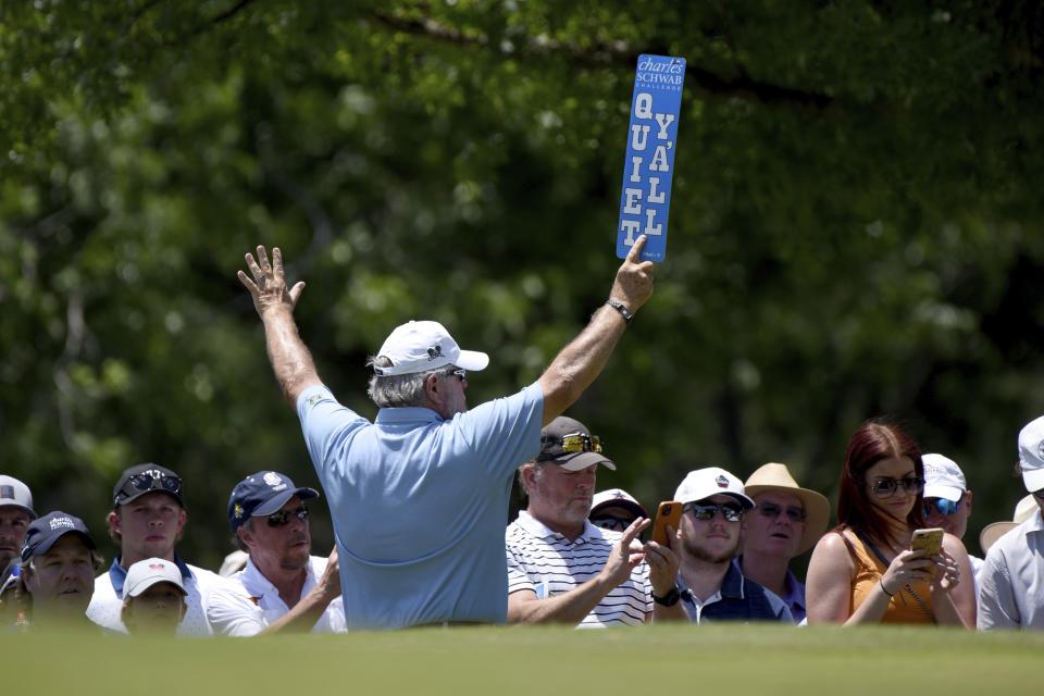 An usher holds up a sign for the gallery as they watches golfers play through the second hole during the third round of the Charles Schwab Challenge golf tournament at the Colonial Country Club, Saturday, May 28, 2022, in Fort Worth, Texas. (AP Photo/Emil Lippe)