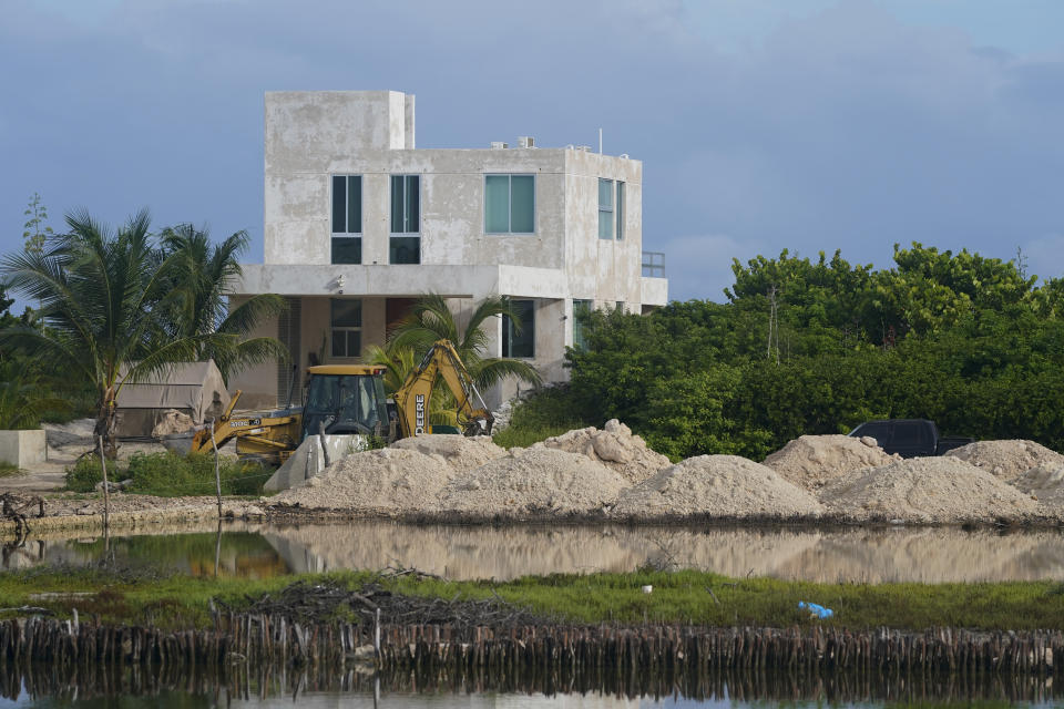 A bulldozer clears a field next to mangroves lining a shoreline near Dzilam de Bravo, in Mexico’s Yucatan Peninsula, Thursday, Oct. 7, 2021. Cutting mangroves has been a crime since 2005. The Yucatan state government said it is aware of complaints of illegal logging yet the harvest has only grown. (AP Photo/Eduardo Verdugo)