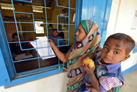 FILE PHOTO: A woman carrying her son arrives to check her name on the draft list of the National Register of Citizens (NRC) at an NRC center in Chandamari village in Goalpara district in the northeastern state of Assam, India, January 2, 2018.  REUTERS/Anuwar Hazarika/File Photo