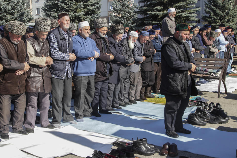 People pray during a protest against the new land swap deal agreed by the heads of the Russian regions of Ingushetia and Chechnya, in Ingushetia's capital Magas, Russia, Monday, Oct. 8, 2018. Ingushetia and the neighboring province of Chechnya last month signed a deal to exchange what they described as unpopulated plots of agricultural land, but the deal triggered massive protests in Ingushetia where it was seen by many as hurting Ingushetia’s interests. (AP Photo/Musa Sadulayev)