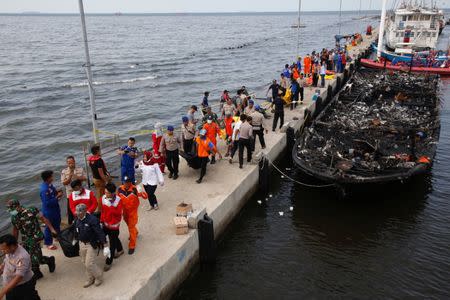 ATTENTION EDITORS - VISUAL COVERAGE OF SCENES OF INJURY OR DEATHSecurity forces, Red Cross and rescue workers carry body bags with the remains of victims from a boat fire at Muara Angke port in Jakarta, Indonesia January 1, 2017. REUTERS/Darren Whiteside