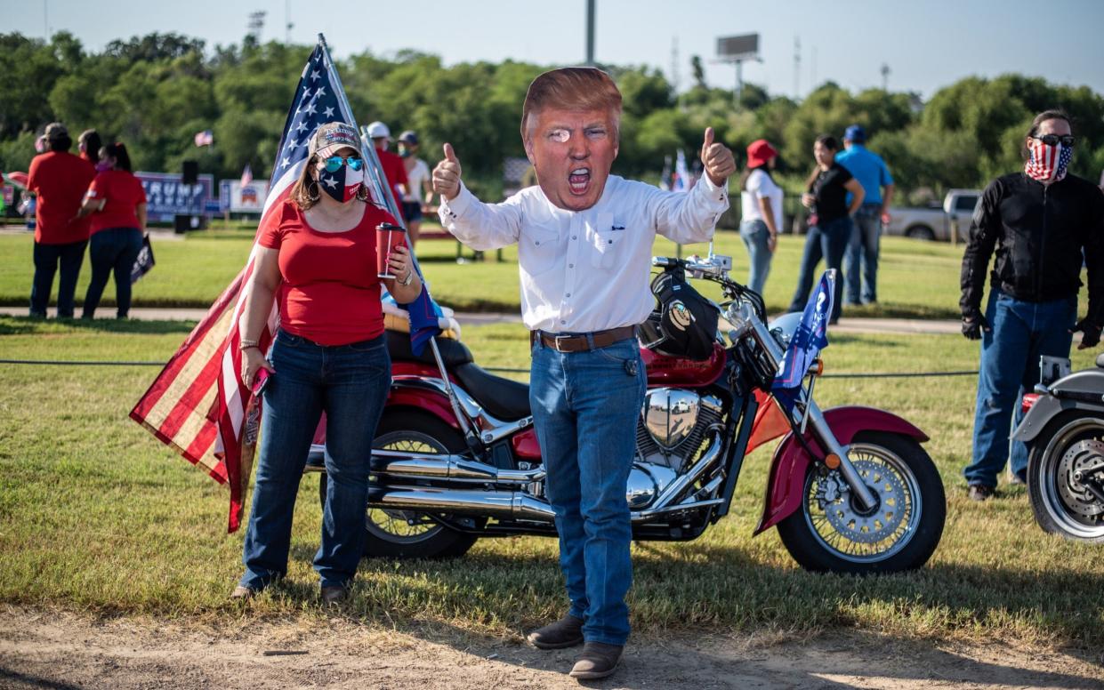 An attendee wears a cutout mask in the likeness of U.S. President Donald Trump during a "Trump Train" rally in Laredo, Texas, U.S - Bloomberg