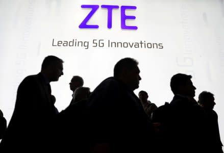 FILE PHOTO - Visitors pass in front of the Chinese telecoms equipment group ZTE Corp booth at the Mobile World Congress in Barcelona, Spain, February 26, 2018. REUTERS/Sergio Perez/File Photo