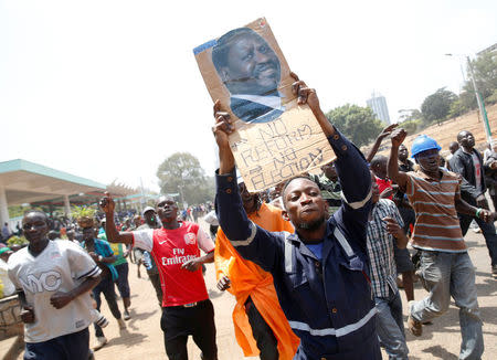 A supporter of Kenyan opposition National Super Alliance (NASA) coalition, carries a banner depicting Kenyan opposition leader Raila Odinga during a protest along a street in Nairobi, Kenya, October 11, 2017. REUTERS/Baz Ratner