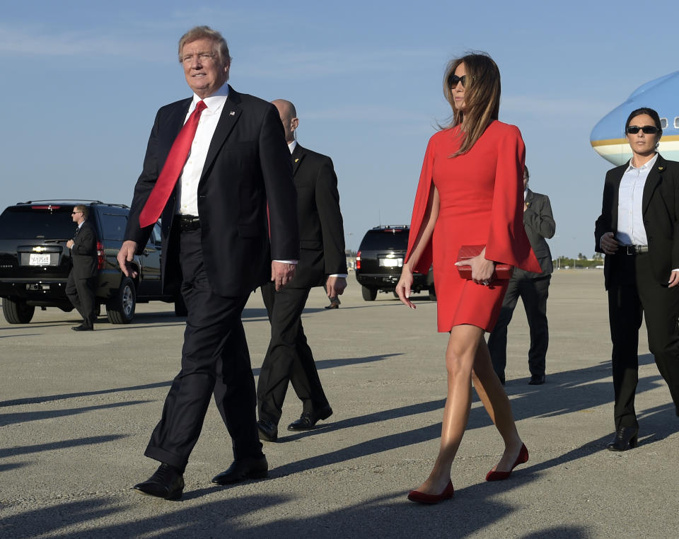 President Donald Trump walks with first lady Melania Trump after she greeted him on the tarmac after he arrived via Air Force One at Palm Beach International Airport in West Palm Beach, Fla., Friday, Feb. 3, 2017. Trump is spending the weekend at Mar-a-Lago. (AP Photo/Susan Walsh)
