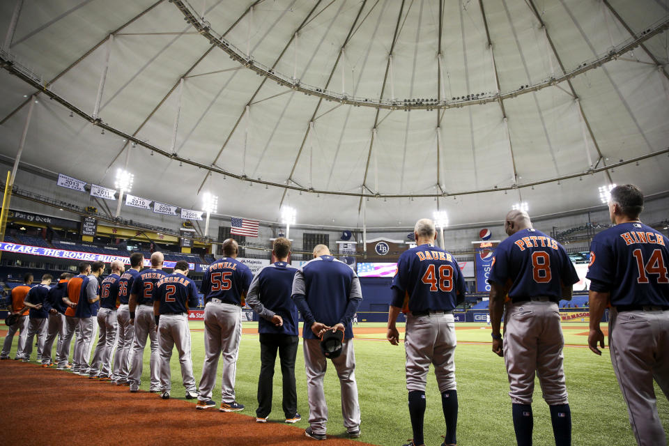 The Houston Astros stand for the national anthem before a baseball against the Texas Rangers in St. Petersburg, Fla. (AP)