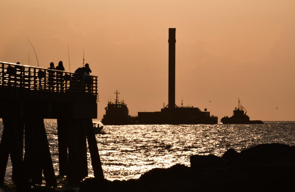 A SpaceX Falcon 9 booster returns to Port Canaveral just after sunrise in December 2021 aboard the SpaceX drone ship A Shortfall of Gravitas.