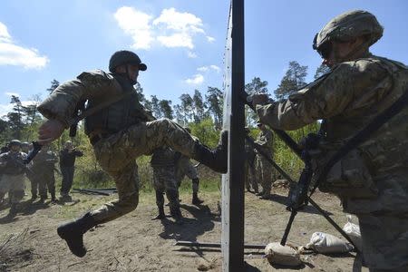 A serviceman of the U.S. Army's 173rd Airborne Brigade Combat Team (R) trains Ukrainian soldiers during a joint military exercise called "Fearless Guardian 2015" at the military training area in Yavoriv, outside Lviv, Ukraine, May 12, 2015. REUTERS/Oleksandr Klymenko