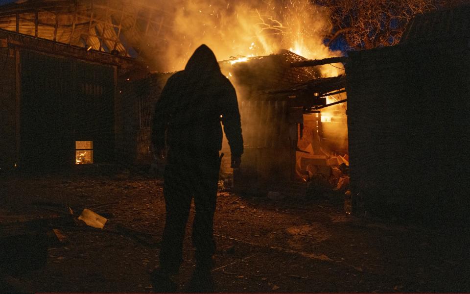 A man is seen in front of a burning single-family house in Bakhmut - Anadolu Agency/Anadolu