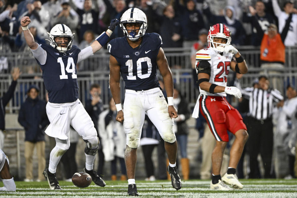 Penn State running back Nicholas Singleton (10) and quarterback Sean Clifford (14) celebrate a touchdown as Maryland defensive back Beau Brade (25) looks on during the first half of an NCAA college football game, Saturday, Nov. 12, 2022, in State College, Pa. (AP Photo/Barry Reeger)