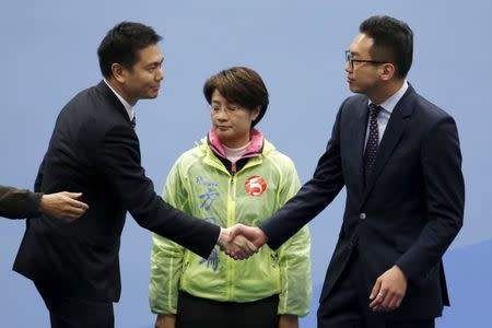 Holden Chow (L), a candidate from the Democratic Alliance for the Betterment and Progress of Hong Kong, congratulates Alvin Yeung (R), a candidate from Civic Party, after Yeung won a Legislative Council by-election in Hong Kong, China February 29, 2016. In the middle is independent candidate Christine Fong. REUTERS/Bobby Yip