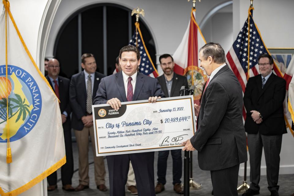 Gov. Ron DeSantis presents a check to Panama City Mayor Greg Brudnicki for Hurricane Michael recovery efforts at City Hall on Jan. 13.