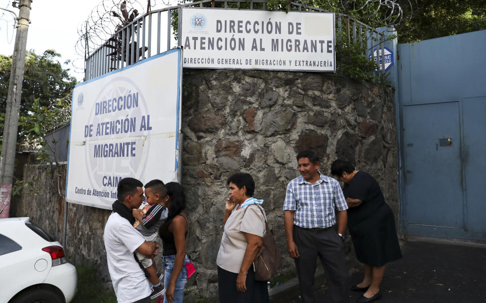 In this Oct. 9, 2019 photo, people gather outside the Migrant Assistance Office in San Salvador, El Salvador. The Trump administration struck a series of agreements with El Salvador, Guatemala and Honduras to stem the flow of migrants at the southern border. Under those pacts, immigrants who pass through those countries on the way to the U.S. are effectively barred from seeking asylum in America. (AP Photo/Eduardo Verdugo)