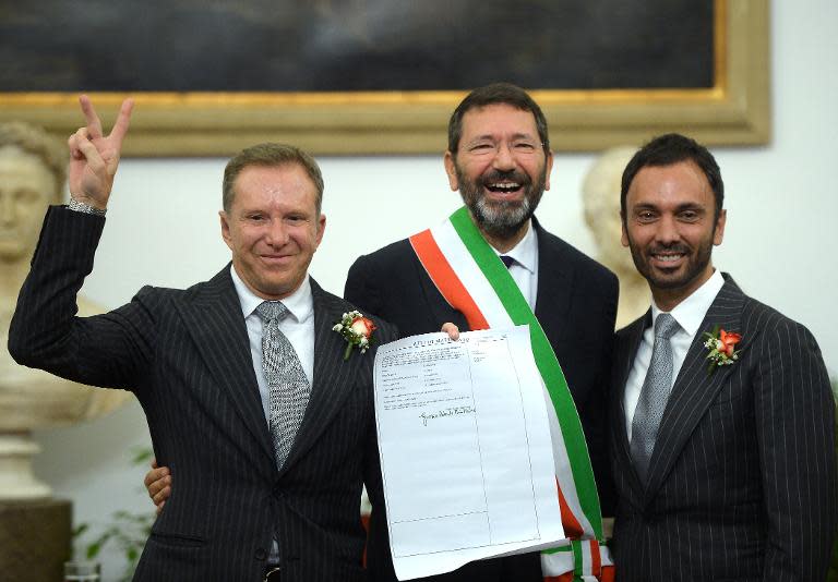 Rome's mayor, Ignazio Marino (C), poses with a gay couple after he registered their marriage on October 18, 2014 at the city hall reception room