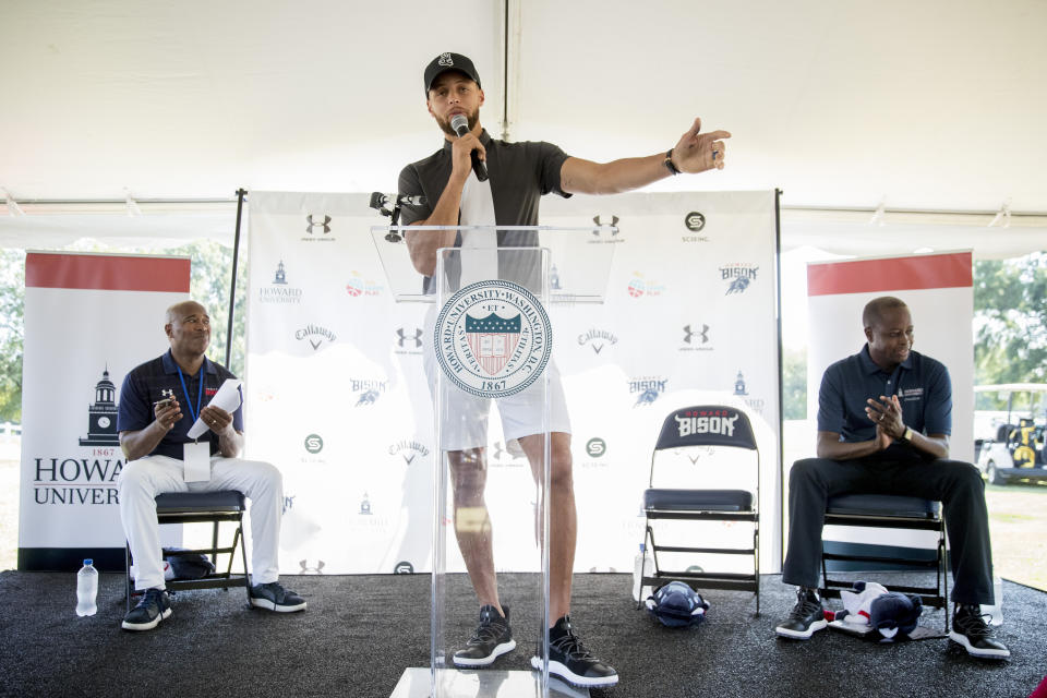 FILE - Golden State Warriors NBA player Stephen Curry speaks as Howard University Athletic Director Kery Davis, left, and Howard University interim president Wayne Frederick look on during a news conference where Curry announced that he would be sponsoring men's and women's golf teams at Howard University, at Langston Golf Course in Washington, Monday, Aug. 19, 2019. (AP Photo/Andrew Harnik, File)