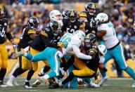 <p>Le’Veon Bell #26 of the Pittsburgh Steelers is wrapped up for a tackle by Ndamukong Suh #93 of the Miami Dolphins in the first half during the Wild Card Playoff game at Heinz Field on January 8, 2017 in Pittsburgh, Pennsylvania. (Photo by Justin K. Aller/Getty Images) </p>