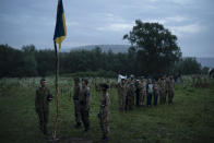 Jóvenes que asisten a un campamento en el que nacionalistas ucranianos les enseñan a empuñar rifles para combatir a Rusia y sus partidadios saludan a la bandera y cantan el himno nacional en Ternopil, Ucrania, el 28 de julio del 2018. (AP Photo/Felipe Dana)