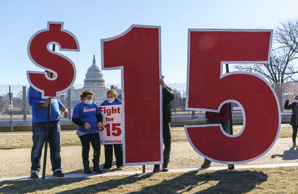 Activists appeal for a $15 minimum wage near the Capitol in Washington, Thursday, Feb. 25, 2021. The $1.9 trillion COVID-19 relief bill being prepped in Congress includes a provision that over five years would hike the federal minimum wage to $15 an hour. (AP Photo/J. Scott Applewhite)