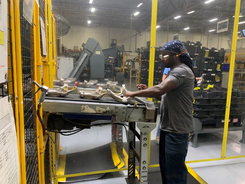 A production worker performs final quality inspection before packaging knuckles for shipment at auto supplier Aludyne in Port Huron