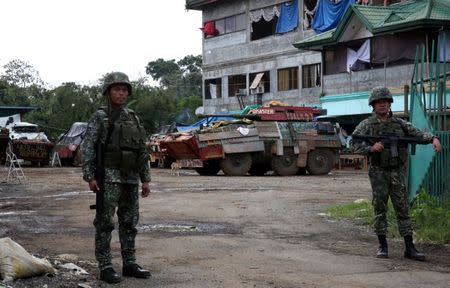 Government soldiers stand on guard in front of their military post during as local government clears the area inside a war-torn in Marawi city, southern Philippines October 19, 2017. REUTERS/Romeo Ranoco