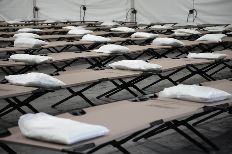 FILE - Bags containing a pillow, towel, and bed sheets are placed on cots inside the dormitory tent during a media tour of a shelter New York City is setting up to house up to 1,000 migrants in the Queens borough of New York, Aug. 15, 2023. Five mayors from around the U.S. want a meeting with President Joe Biden to ask for help controlling the continued arrival of large groups of migrants to their cities. The mayors of Denver, Chicago, Houston, New York and Los Angeles say in a letter to Biden that there has been little to no coordination, support or resources and that is leading to a crisis. (AP Photo/Mary Altaffer, File)