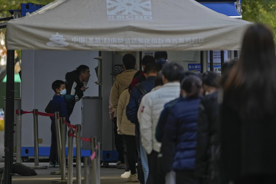 People line up for their routine COVID-19 tests at a coronavirus testing site at the central business district in Beijing, Wednesday, Nov. 16, 2022. Chinese authorities locked down a major university in Beijing on Wednesday after finding one COVID-19 case as they stick to a "zero-COVID" approach despite growing public discontent. (AP Photo/Andy Wong)